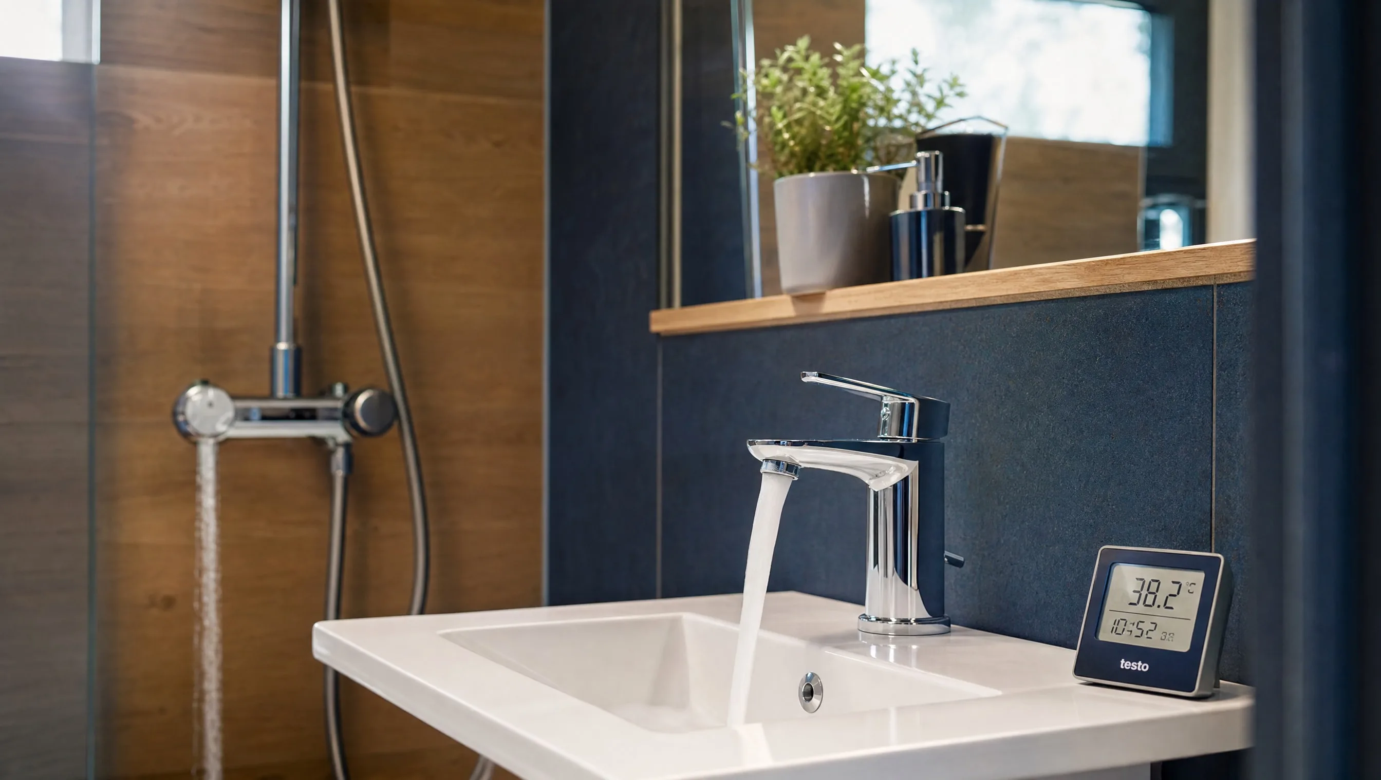 Salle de bain neuve avec mitigeur thermostatique en cours de test et thermomètre digital posé sur le lavabo